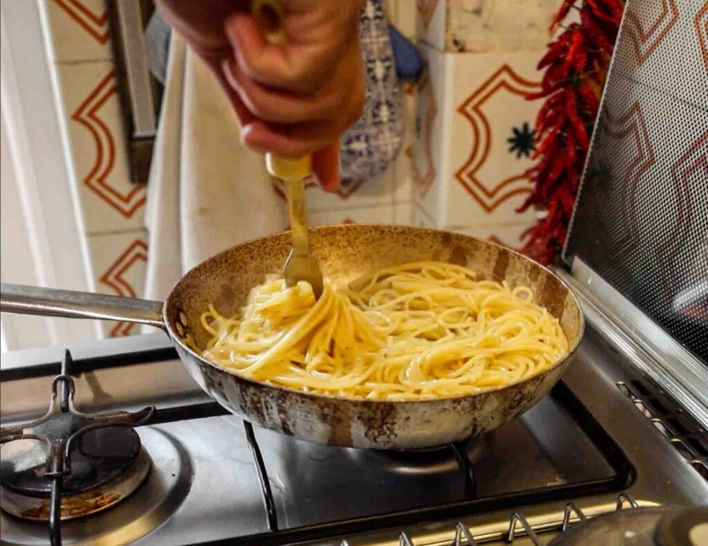 stirring pasta for aglio e olio